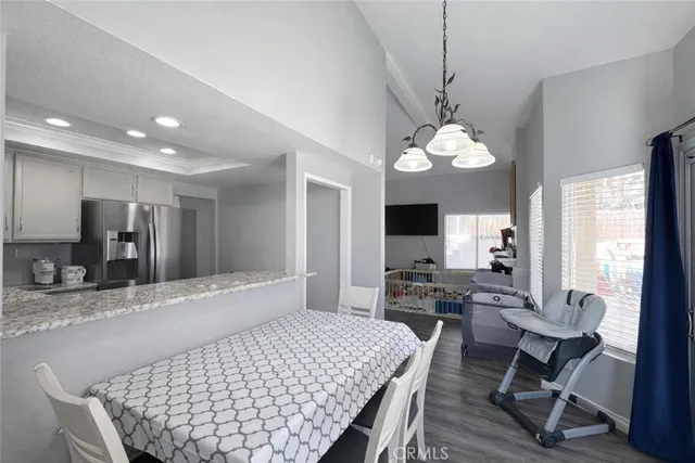 a very nice looking dining room with a large bed and a chandelier