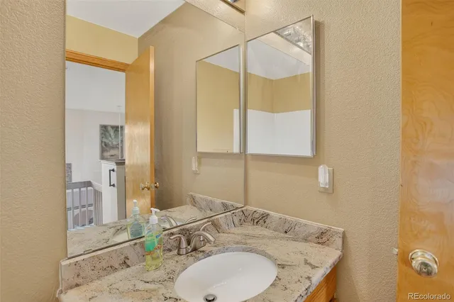a bathroom with a granite countertop sink and a mirror