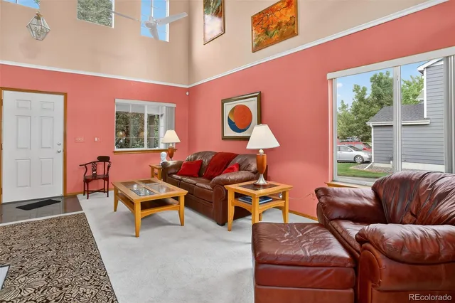 a living room with furniture a rug and a large window