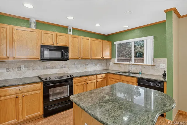 a kitchen with stainless steel appliances granite countertop a sink a stove and microwave