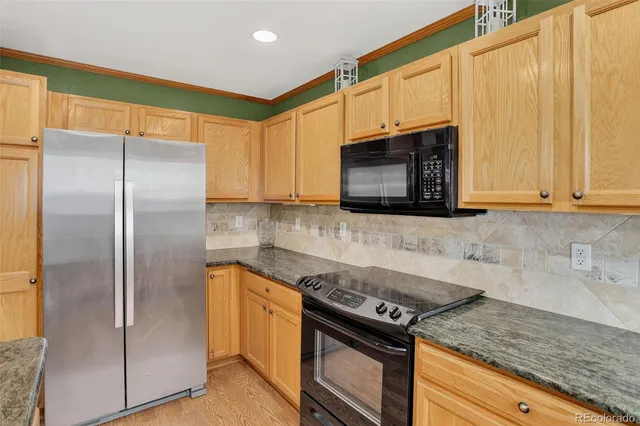 a kitchen with stainless steel appliances granite countertop a refrigerator stove and microwave
