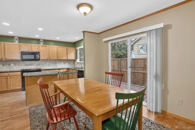 a kitchen with stainless steel appliances granite countertop a stove a sink a microwave and a dining table