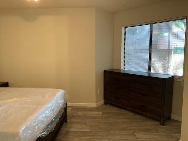 a bed sitting in a bedroom next to a window