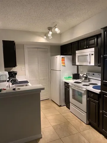 a kitchen with a sink stainless steel appliances and white cabinets