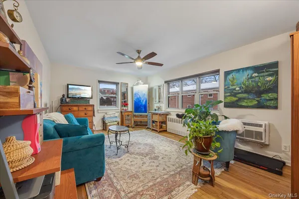 a living room with furniture a flat screen tv and a window