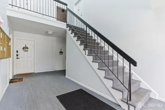a view of staircase with railing and white walls
