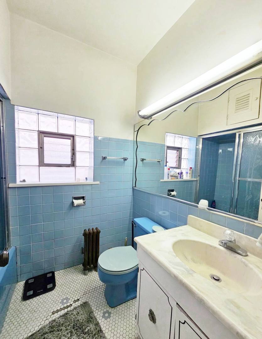 7949 South Rhodes Avenue Chicago, IL 60619 - Photo 14 of 14 a bathroom with a sink a toilet and mirror