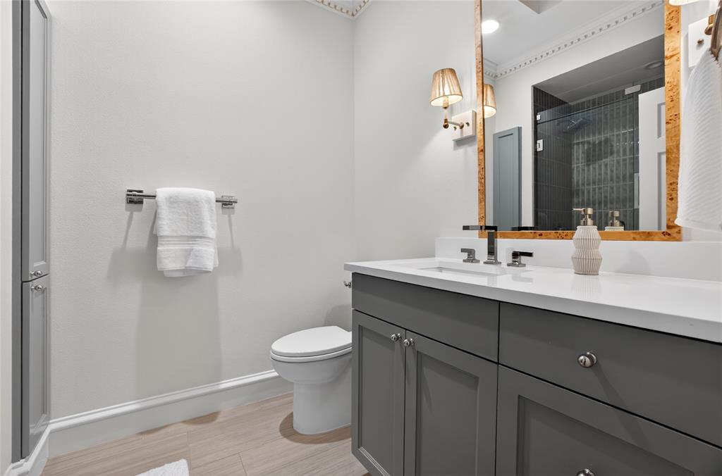 6331 Waggoner Drive Dallas, TX 75230 - Photo 25 of 36 a bathroom with a sink mirror and toilet