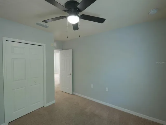 an empty room with a chandelier fan