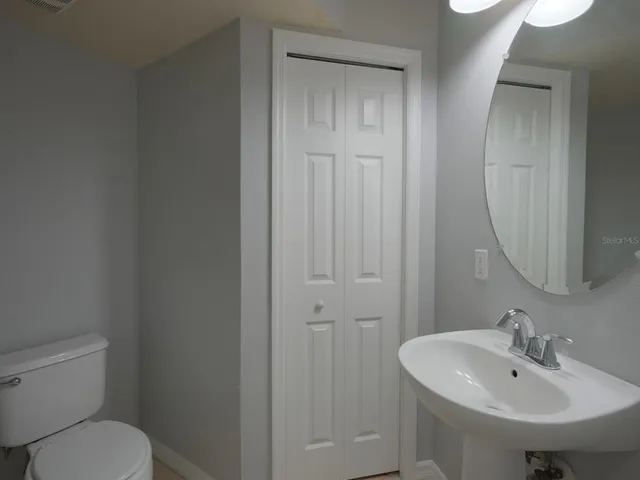 a bathroom with a sink toilet and a mirror