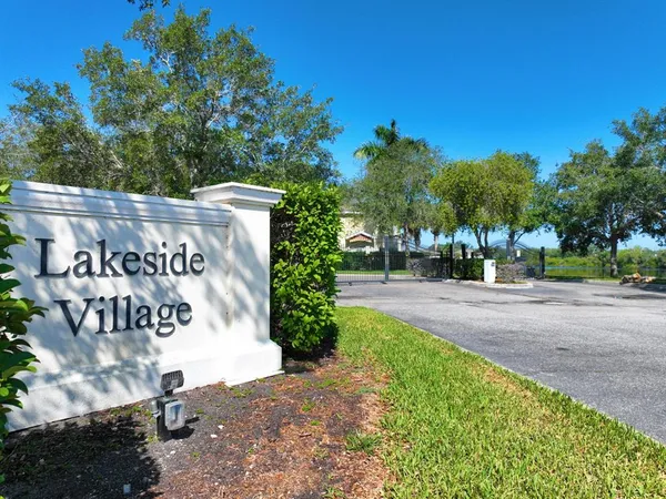 a sign board with buildings in the background