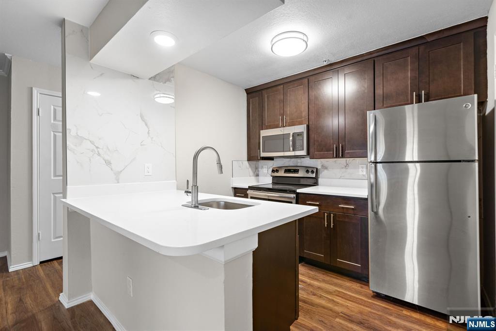 690 Route 23, Unit R2 Wayne, NJ 07470 - Photo 3 of 11 a kitchen with refrigerator a sink and cabinets