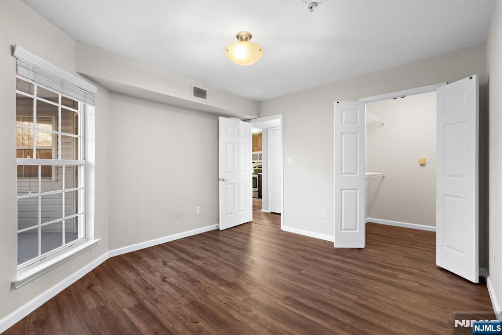 690 Route 23, Unit R2 Wayne, NJ 07470 - Photo 8 of 11 a view of an empty room with wooden floor and a window