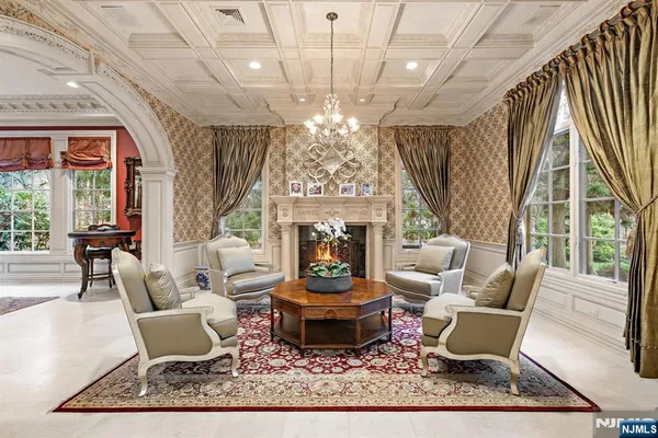 a living room with furniture a chandelier and a fireplace