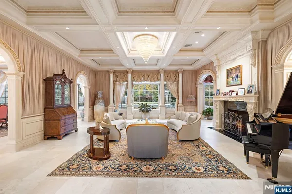 a living room with furniture a fireplace and a chandelier