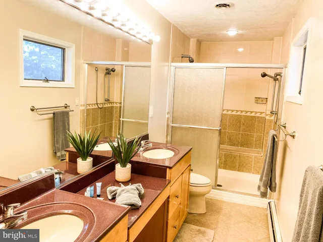 a bathroom with a granite countertop sink toilet and shower