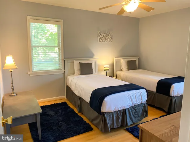 a bedroom with two beds and a dresser