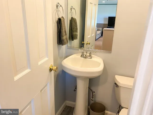 a bathroom with a sink a toilet and mirror