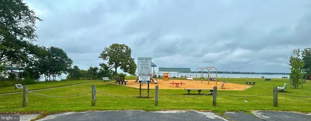 a view of a swimming pool with a big yard and large trees