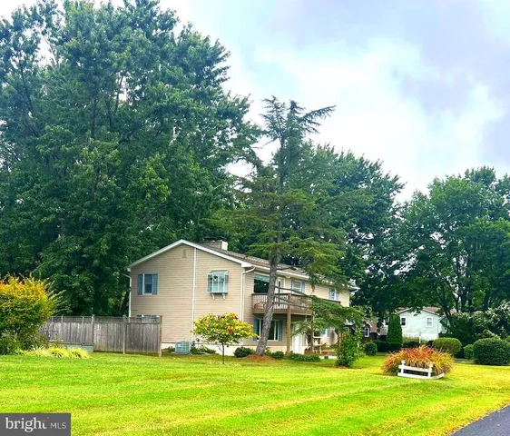 a house view with swimming pool and trees in the background