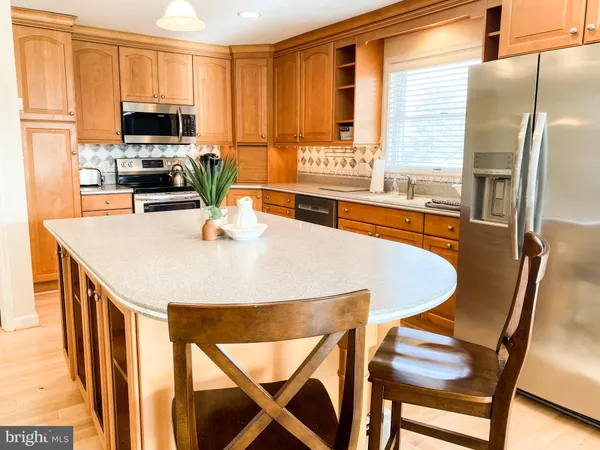 a kitchen with stainless steel appliances granite countertop a stove a refrigerator a microwave a sink and a refrigerator