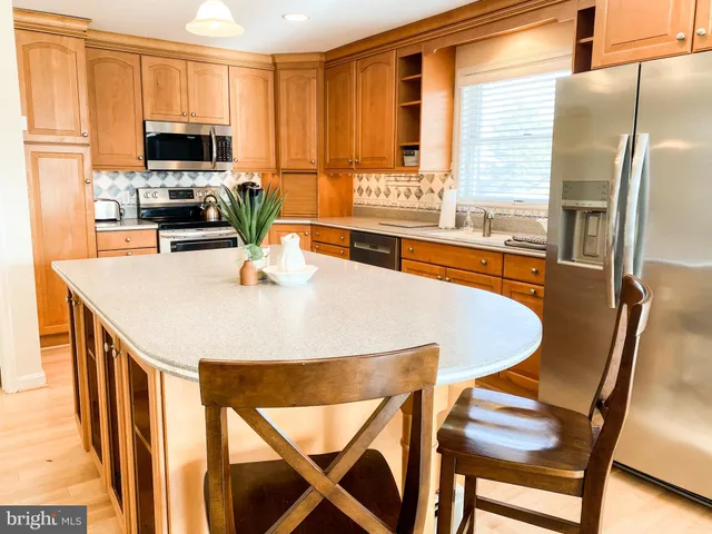 a kitchen with stainless steel appliances granite countertop a stove a refrigerator a microwave a sink and a refrigerator