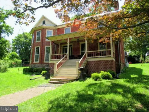 front view of a brick house with a yard