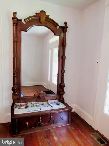 a view of a a dining room with furniture window and wooden floor