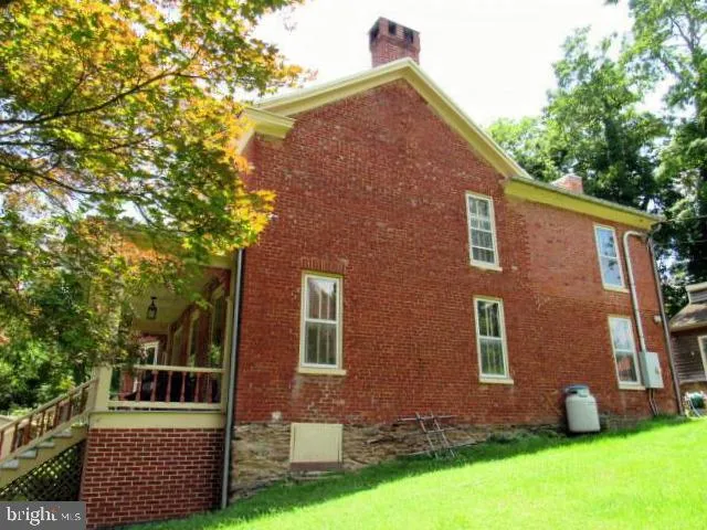 a view of a house with a small yard plants and large tree