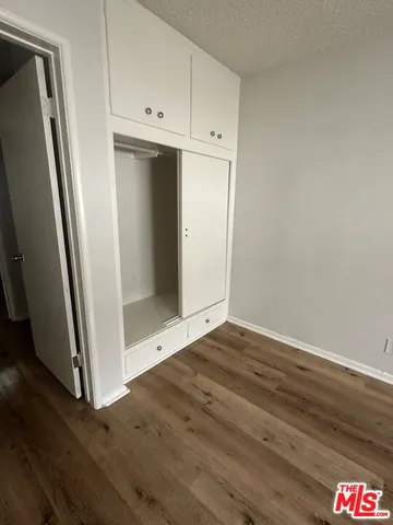 an empty room with wooden floor and entrance