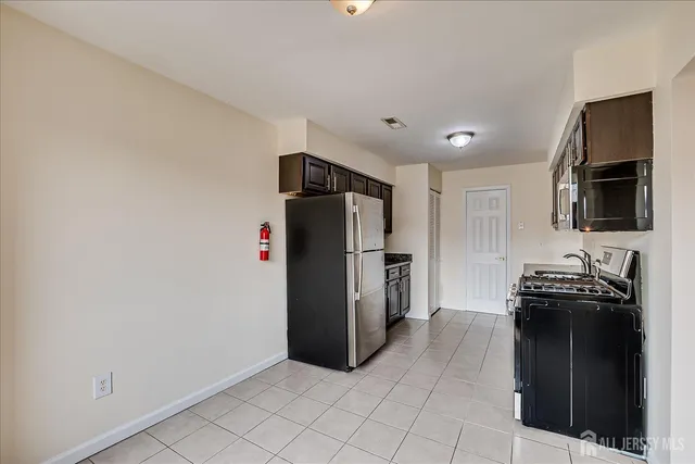 a kitchen with stainless steel appliances granite countertop a refrigerator and a stove top oven