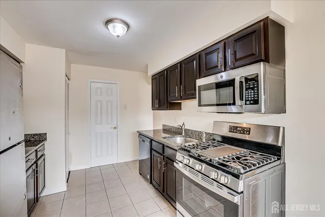 a kitchen with granite countertop a sink stove and cabinets