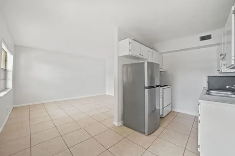a kitchen with granite countertop a refrigerator and a stove top oven