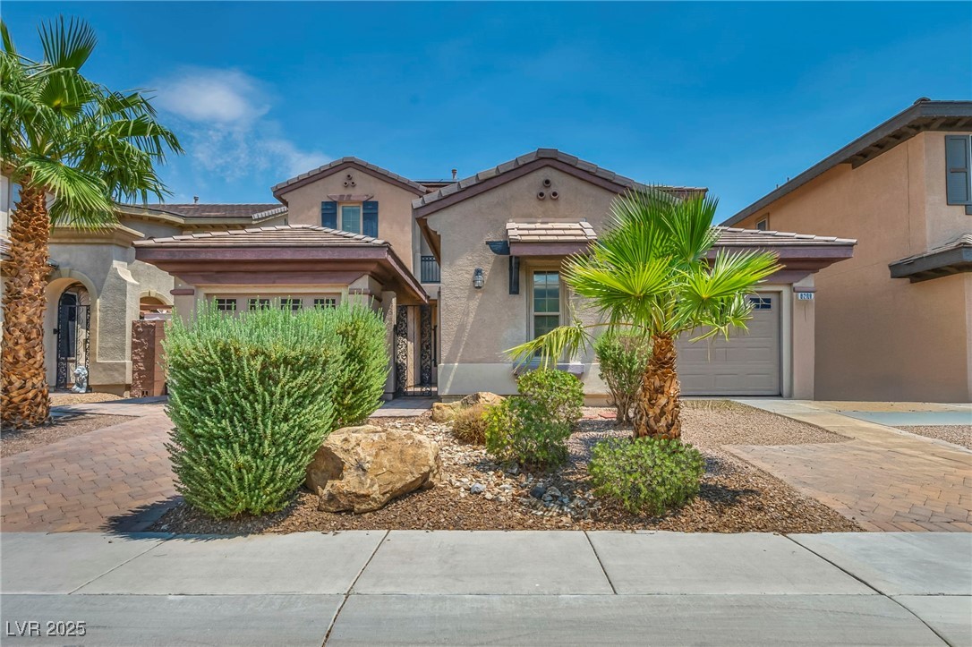 8208 Seven Falls Street North Las Vegas, NV 89085 - Photo 1 of 69 Mediterranean / spanish house featuring an attached garage, stucco siding, decorative driveway, and a tiled roof