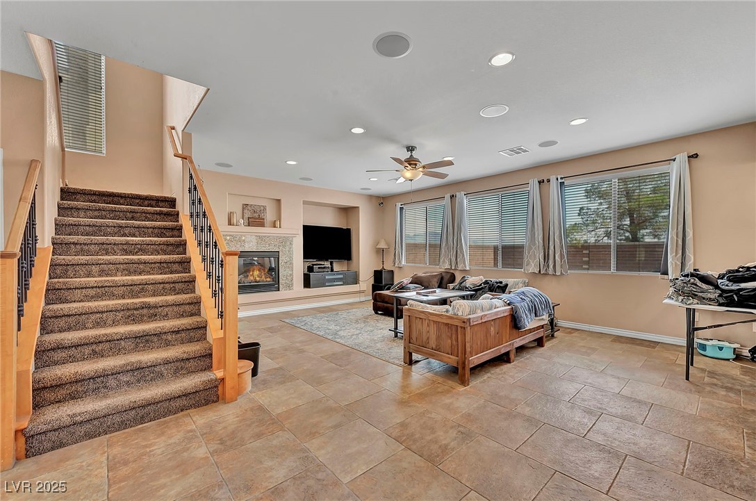 8208 Seven Falls Street North Las Vegas, NV 89085 - Photo 13 of 69 Living area featuring recessed lighting, a glass covered fireplace, stairway, and ceiling fan