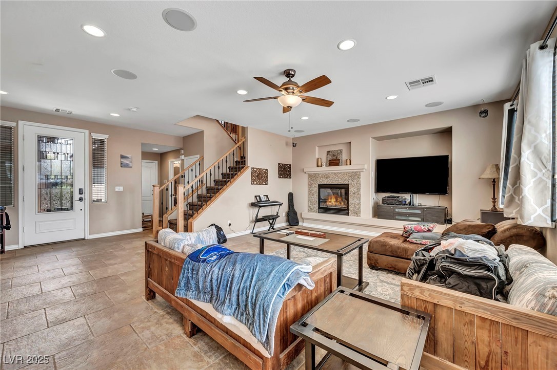 8208 Seven Falls Street North Las Vegas, NV 89085 - Photo 16 of 69 Living area with stairs, a glass covered fireplace, recessed lighting, and ceiling fan