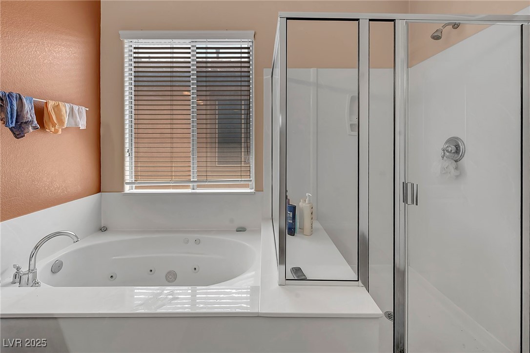 8208 Seven Falls Street North Las Vegas, NV 89085 - Photo 30 of 69 Full bathroom featuring a shower stall, a whirlpool tub, and a textured wall