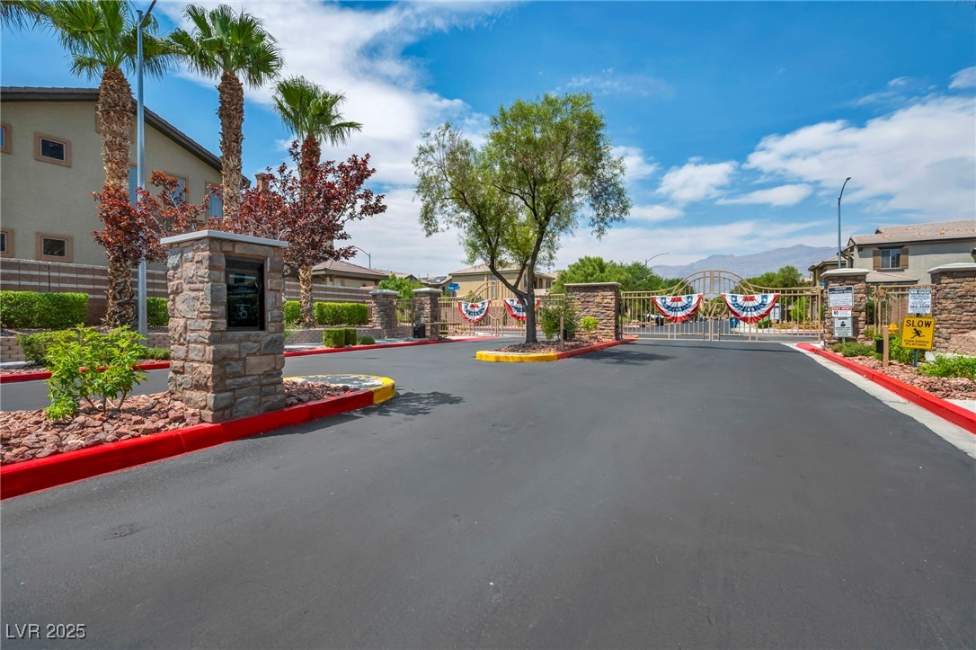 8208 Seven Falls Street North Las Vegas, NV 89085 - Photo 56 of 69 View of asphalt street featuring curbs, a gate, a gated entry, street lights, and a residential view