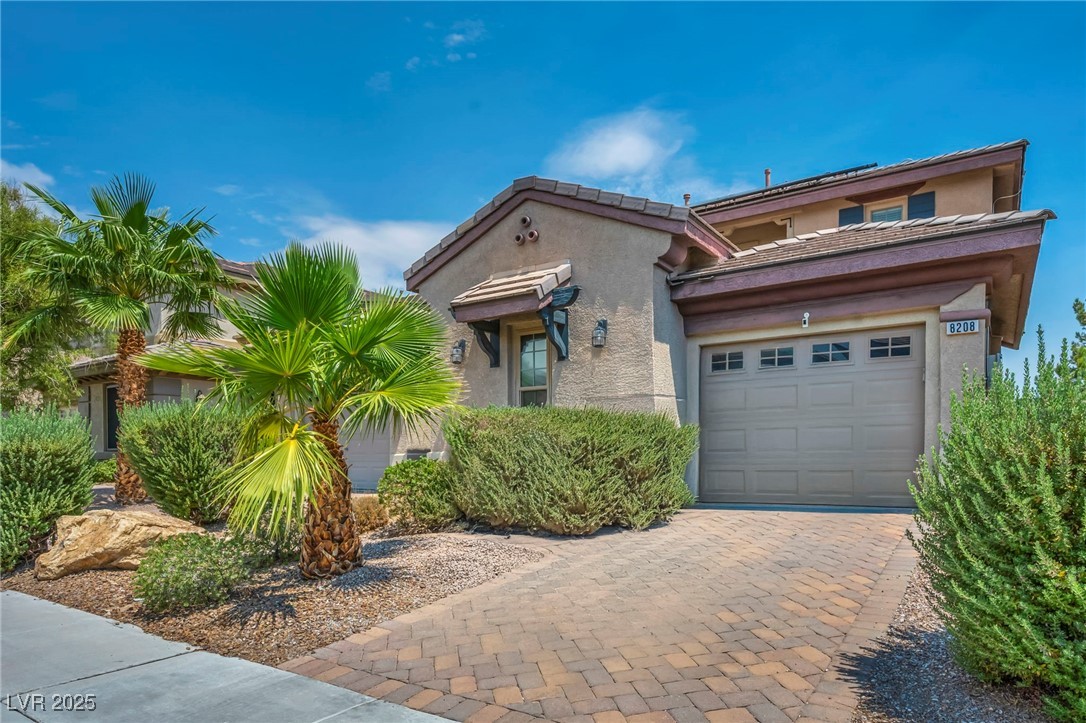 8208 Seven Falls Street North Las Vegas, NV 89085 - Photo 59 of 69 Mediterranean / spanish-style house featuring a tiled roof, stucco siding, decorative driveway, and a garage