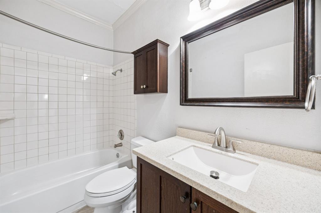 5310 Keller Springs Road, Unit 221 Dallas, TX 75248 - Photo 21 of 29 a bathroom with a toilet a sink a mirror a bathtub and vanity