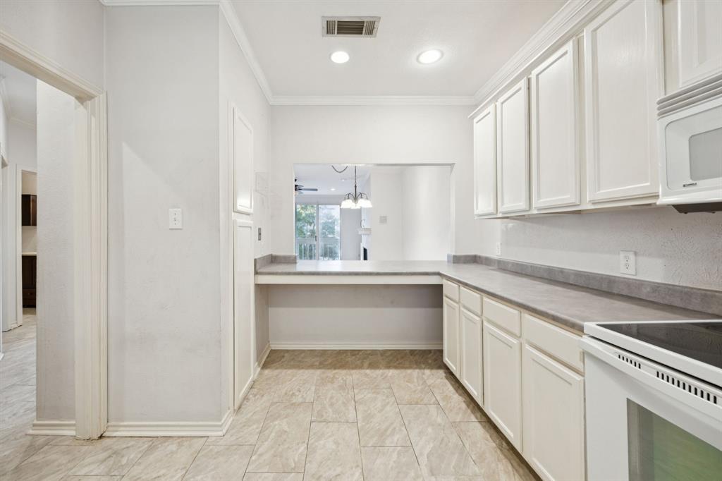 5310 Keller Springs Road, Unit 221 Dallas, TX 75248 - Photo 6 of 29 a kitchen with granite countertop white cabinets and white appliances