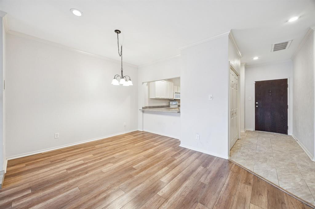 5310 Keller Springs Road, Unit 221 Dallas, TX 75248 - Photo 8 of 29 a view of empty room with wooden floor and kitchen