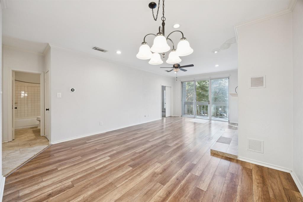 5310 Keller Springs Road, Unit 221 Dallas, TX 75248 - Photo 10 of 29 a view of a room with wooden floor and chandelier