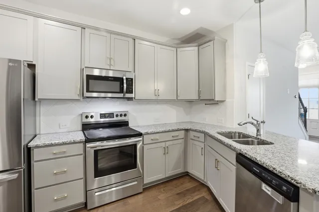 a kitchen with white cabinets stainless steel appliances and sink