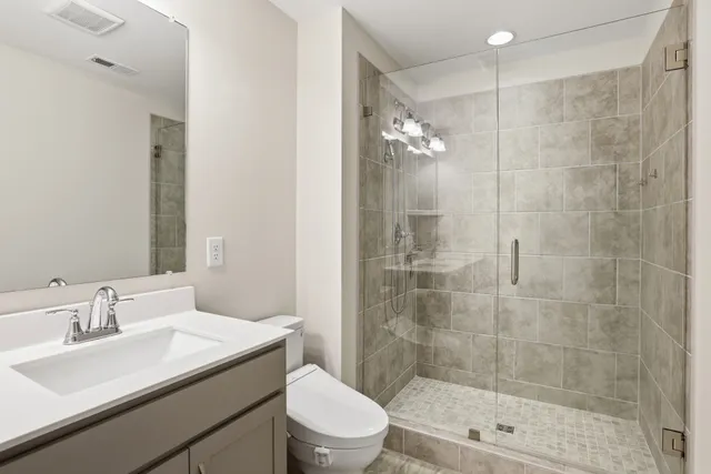 a bathroom with a sink a toilet and shower