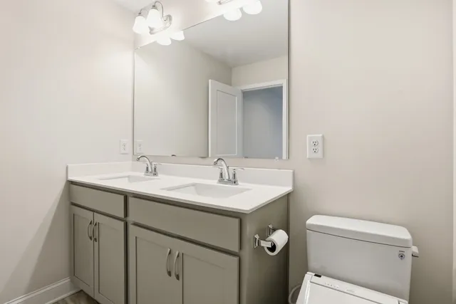 a bathroom with a sink a toilet and a mirror