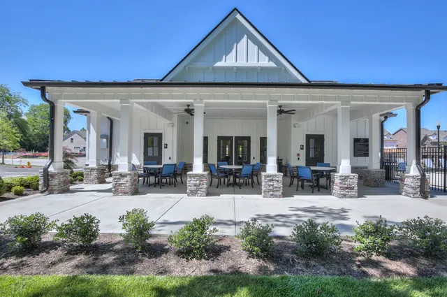 a view of a house with potted plants and a dining table and chairs