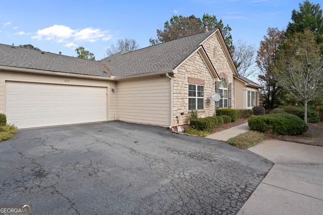a view of a house with a yard and potted plants