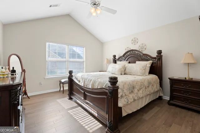 a bedroom with a bed wooden floor and window