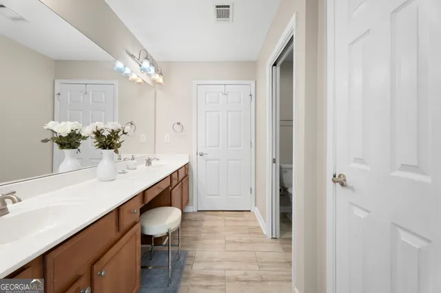 a bathroom with a granite countertop sink a toilet and shower